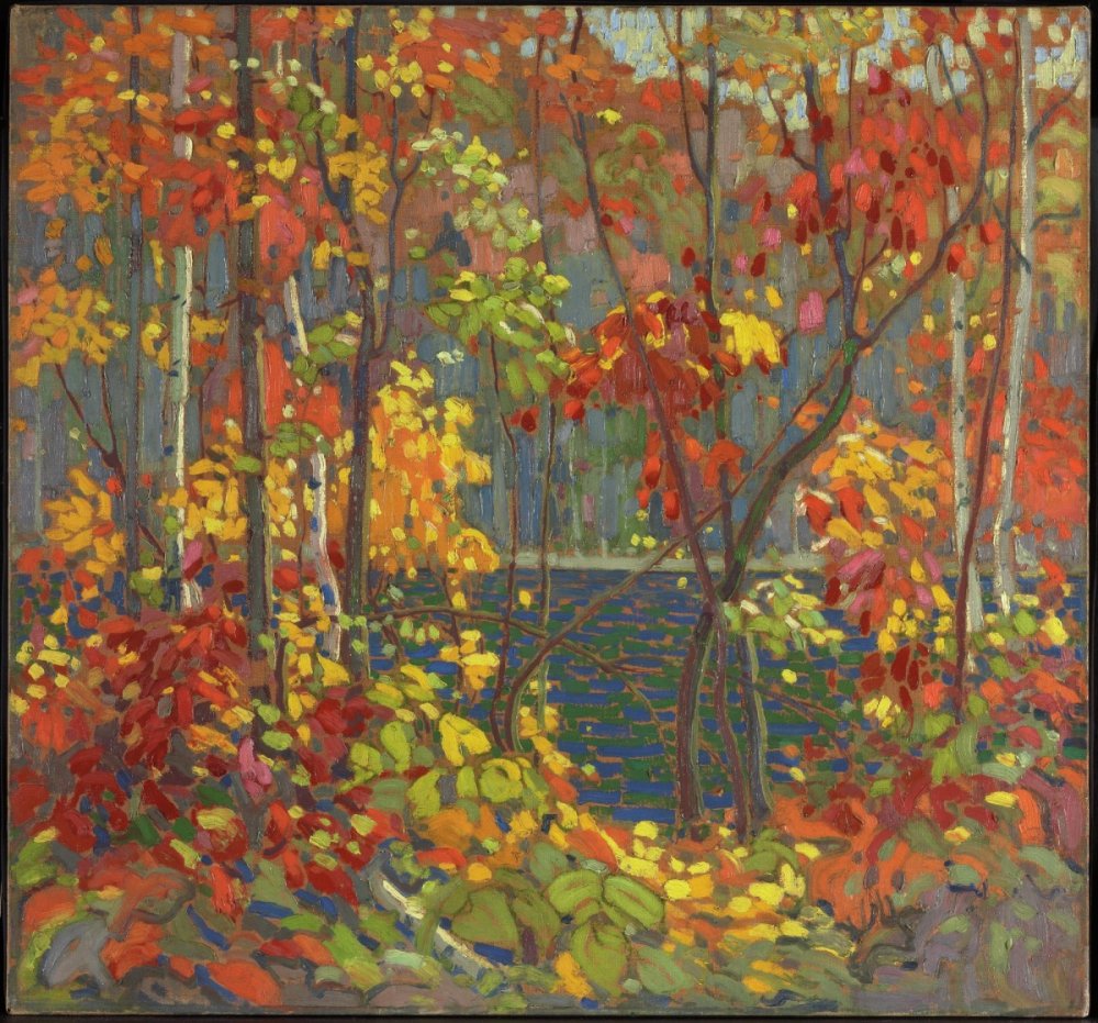 A forest scene painted with yellow and orange, red and green, of leaves and thin trees like silver birch obscuring a rippling pond.